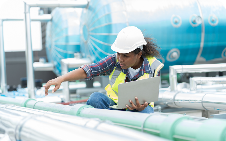 Worker assessing industrial piping system
