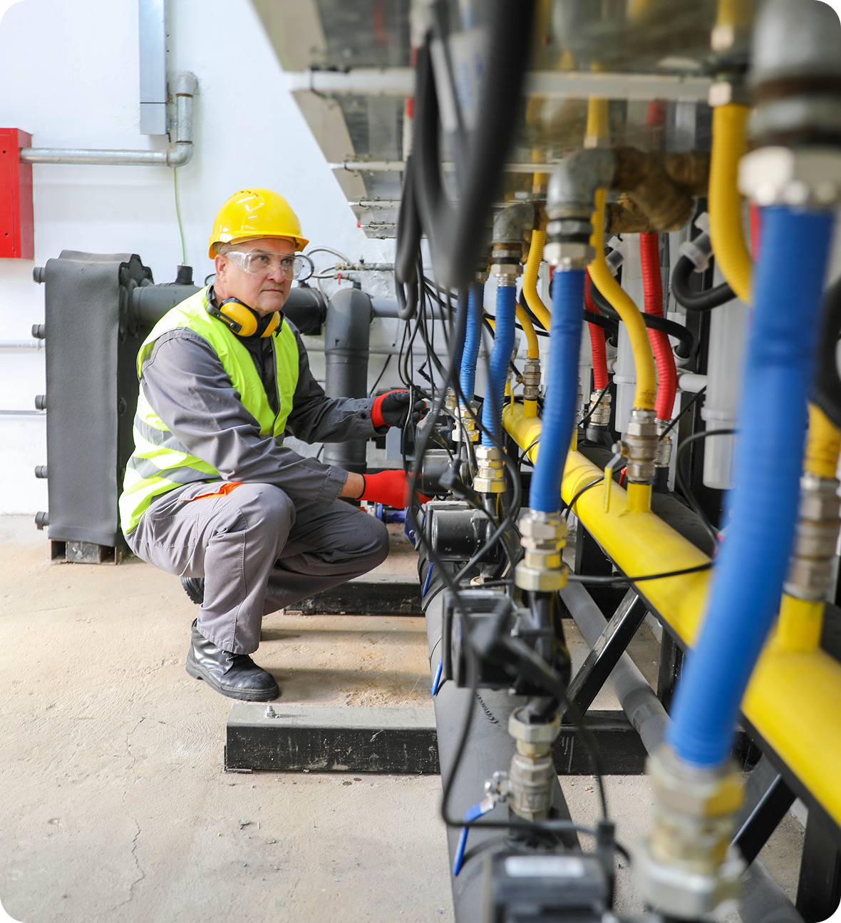 Worker examining colorful industrial pipes