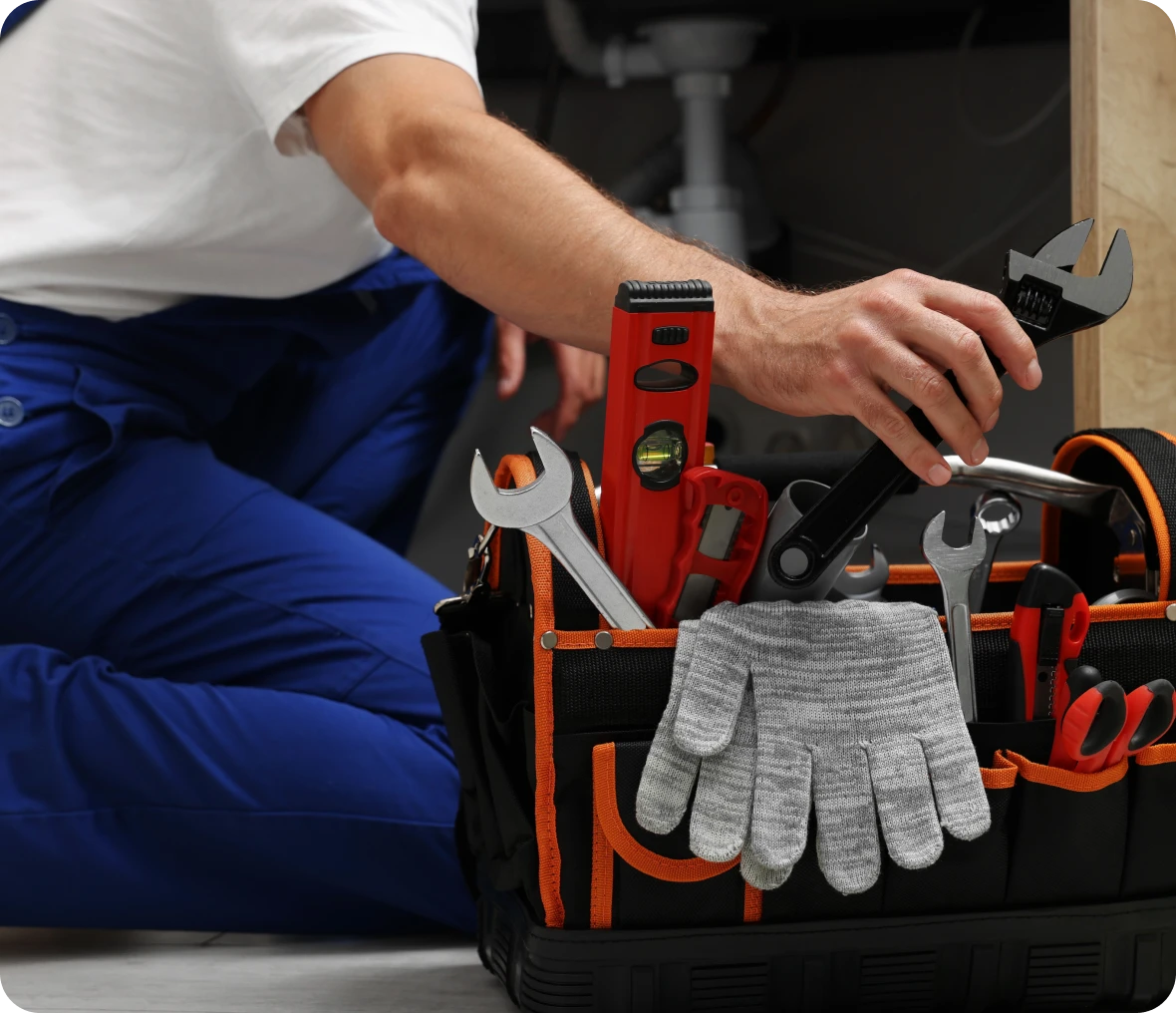 Hand reaching for wrench in toolbag